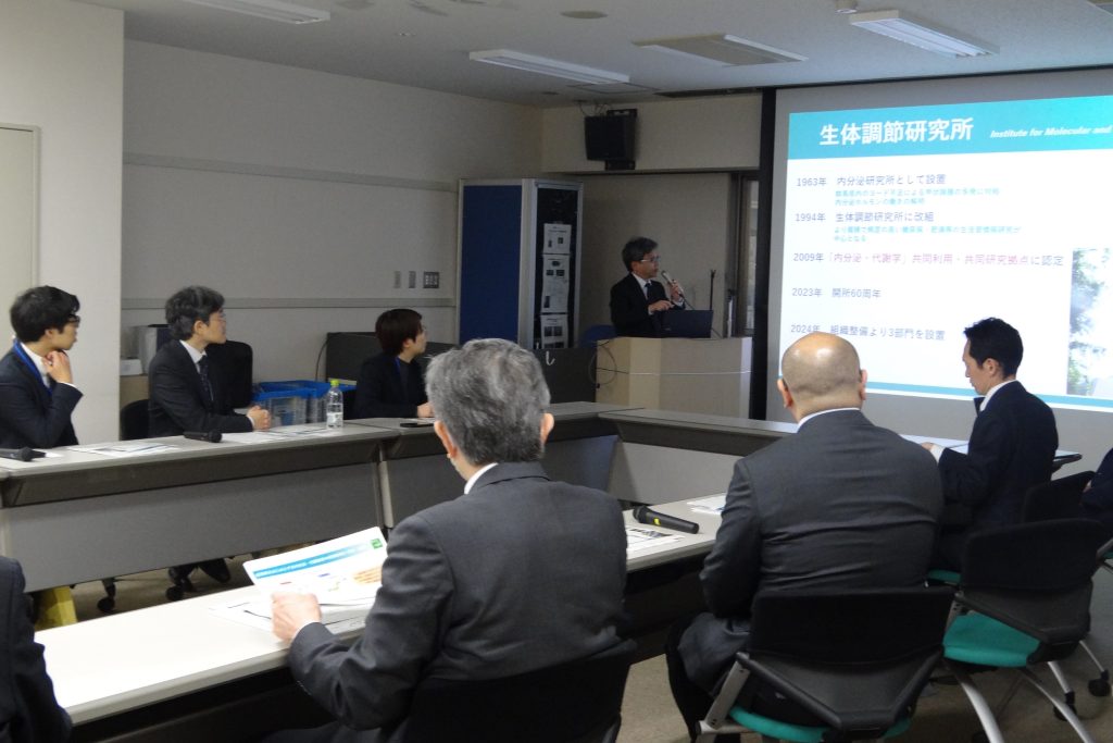 生体調節研究所で説明を受ける板倉課長(左から2人目)ら